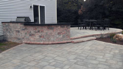 bi-level patio with seating area and an outdoor kitchen