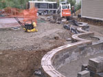 A retaining wall in progress with a lower-level fire pit